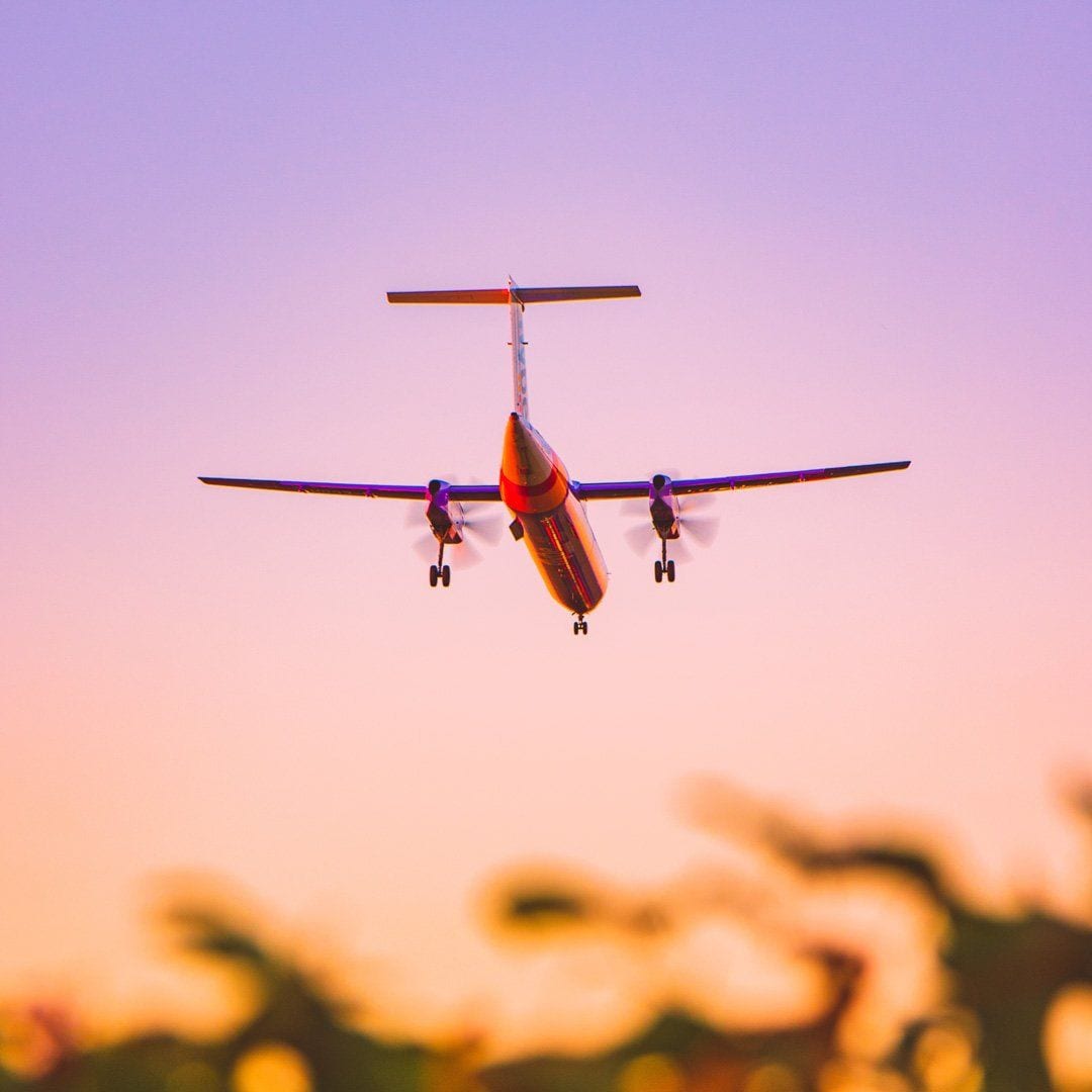 A passenger plane coming in to land at sunset